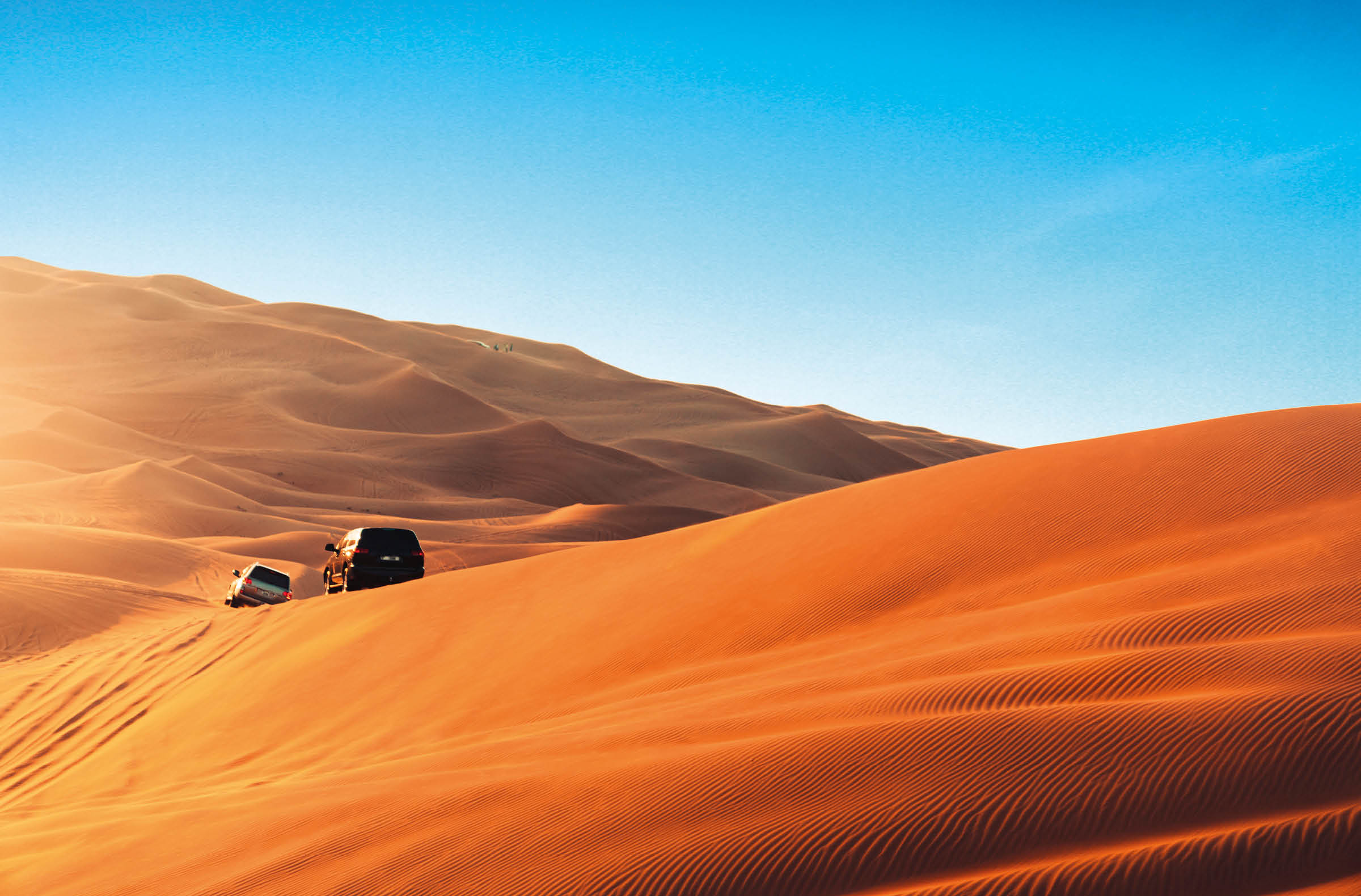 Desert safari outside Dubai, UAE. Adventure, extreme sports, tourist activities in the desert. Sport car driving on sand dunes. Orange golden sand in the desert.