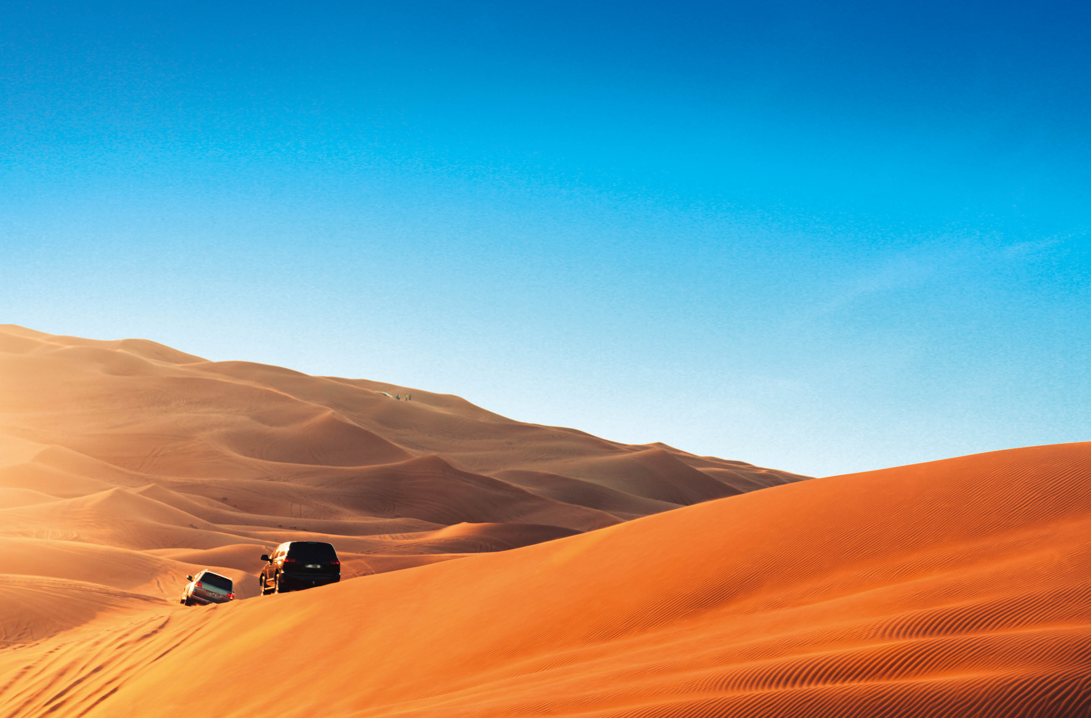 Desert safari outside Dubai, UAE. Adventure, extreme sports, tourist activities in the desert. Sport car driving on sand dunes. Orange golden sand in the desert.