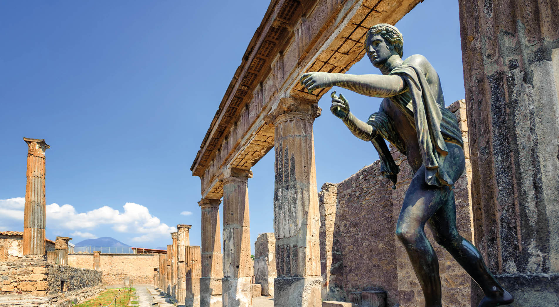 Ruins of the antique Temple of Apollo with bronze Apollo statue in Pompeii, Naples, Italy. Pompeii was destroyed by Vesuvius eruption in 79 AD.
