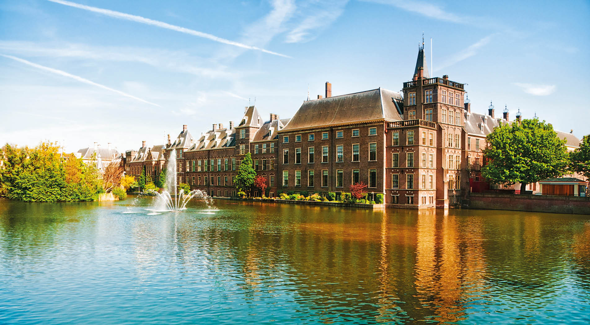 Binnenhof (Dutch Parliament), The Hague (Den Haag), The Netherlands. Visible are Historic buildings, art museum Mauritshuis along the pond Hofvijver, fountain and beautiful cloudscape over the reflection in the water.