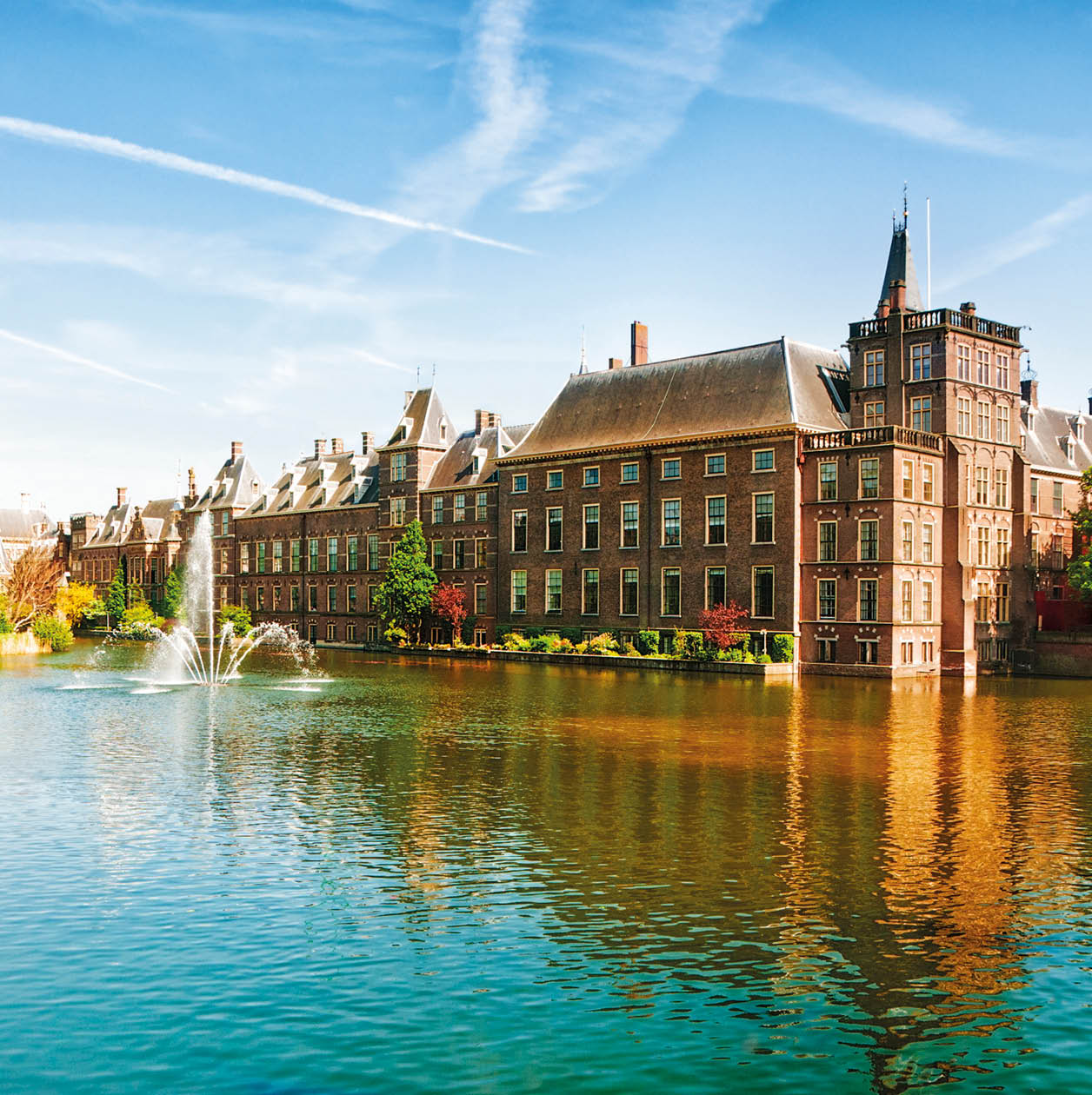 Binnenhof (Dutch Parliament), The Hague (Den Haag), The Netherlands. Visible are Historic buildings, art museum Mauritshuis along the pond Hofvijver, fountain and beautiful cloudscape over the reflection in the water.