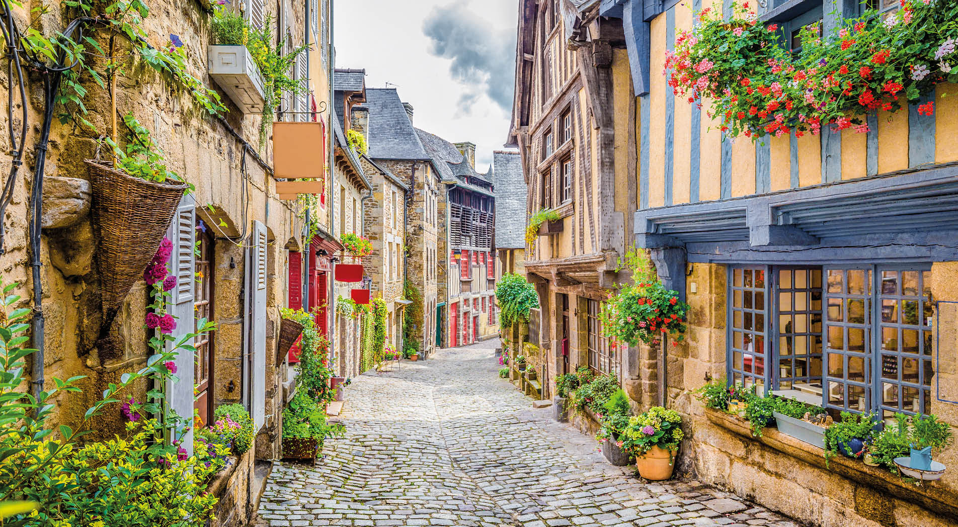 Beautiful view of scenic narrow alley with historic traditional houses and cobbled street in an old town in Europe with blue sky and clouds in summer with retro vintage Instagram grunge filter effect