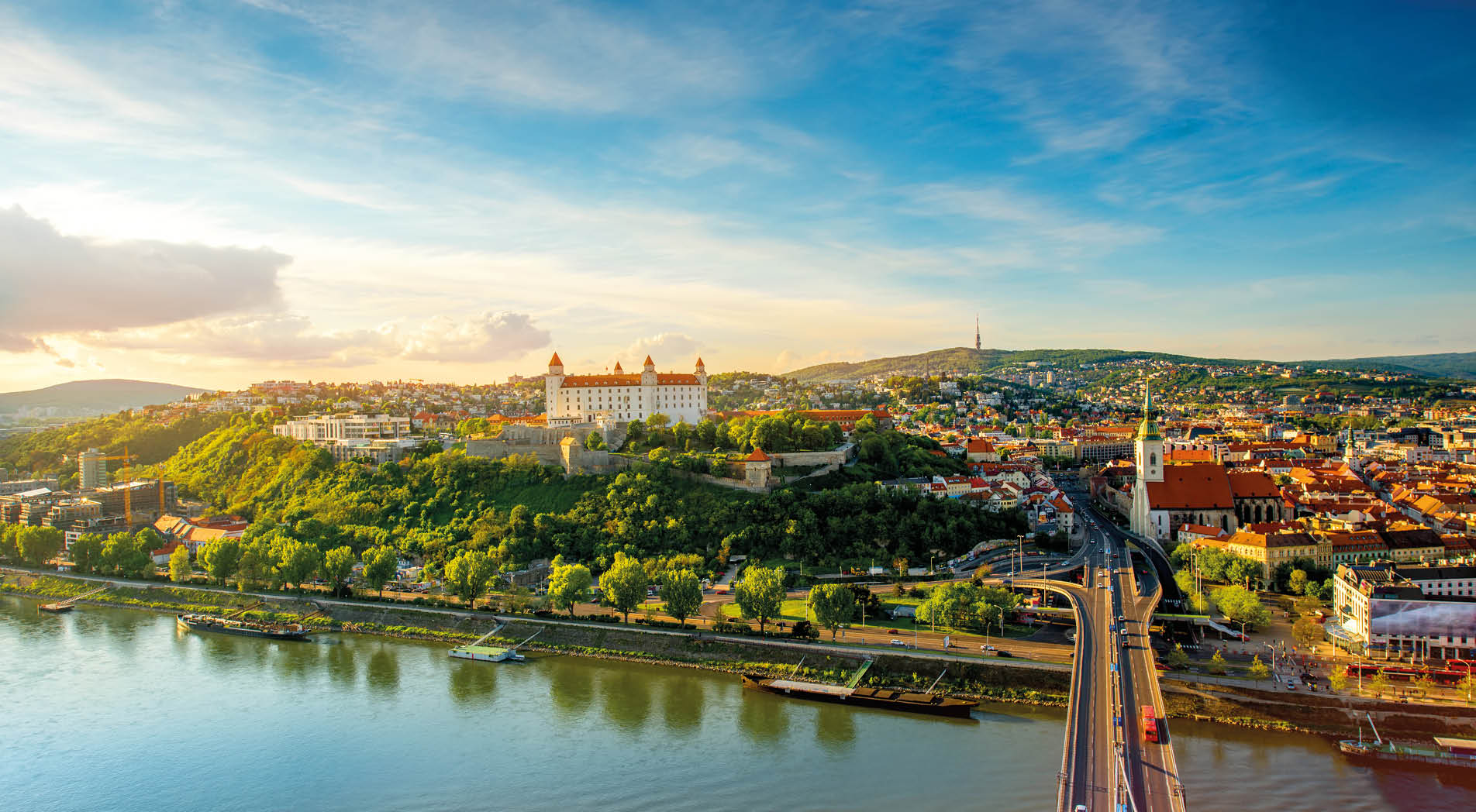 Bratislava aerial cityscape view on the old town with Saint Martin's cathedral, castle hill and Danube river on the sunset in Slovakia. Wide angle view with copy space