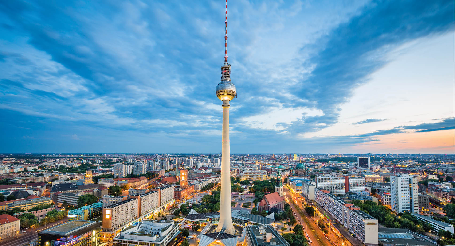 Aerial view of Berlin skyline with famous TV tower at Alexanderplatz and dramatic cloudscape in twilight during blue hour at dusk, Germany.