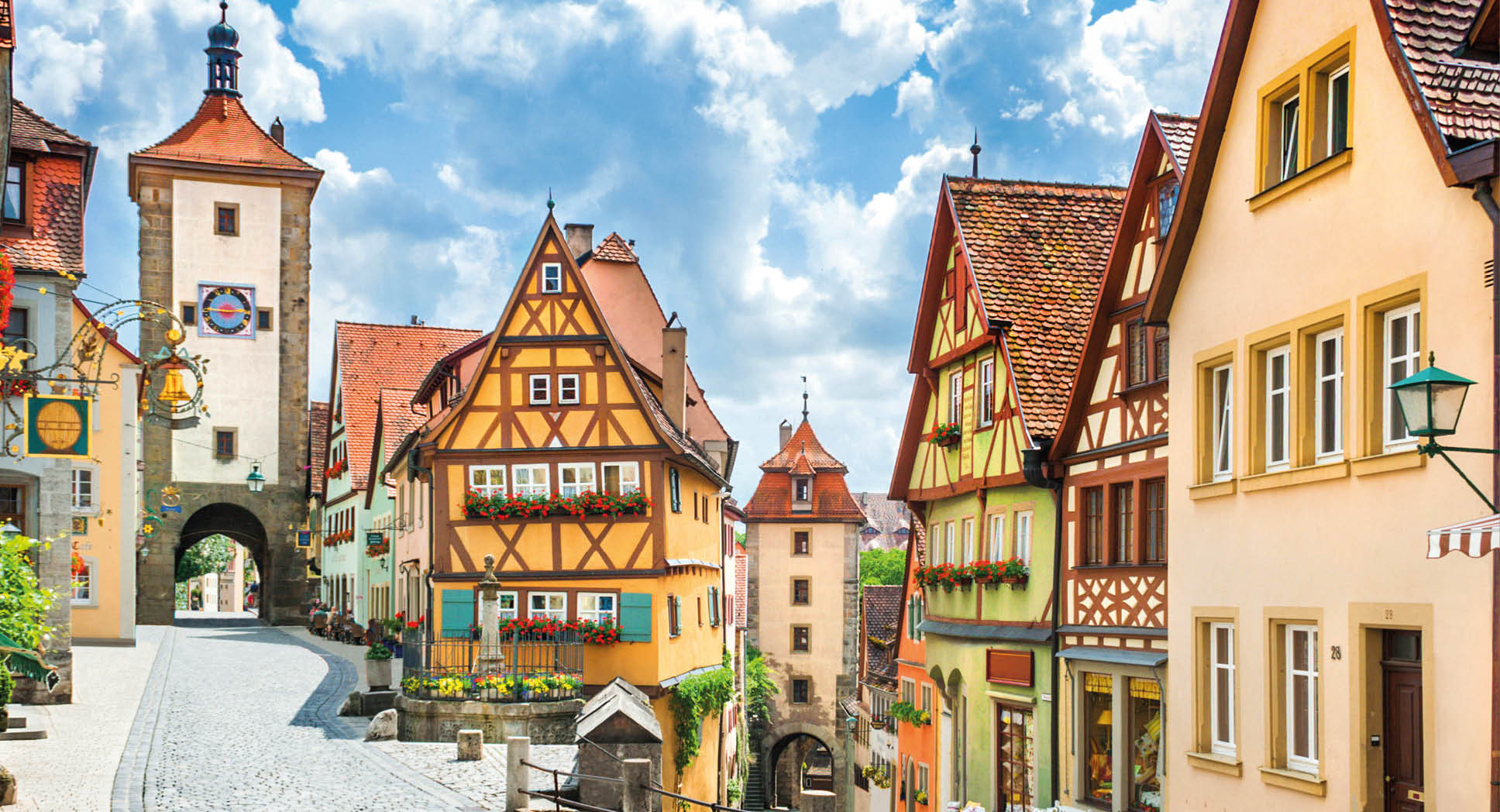 Beautiful postcard view of the famous historic town of Rothenburg ob der Tauber on a sunny day with blue sky and clouds in summer, Franconia, Bavaria, Germany