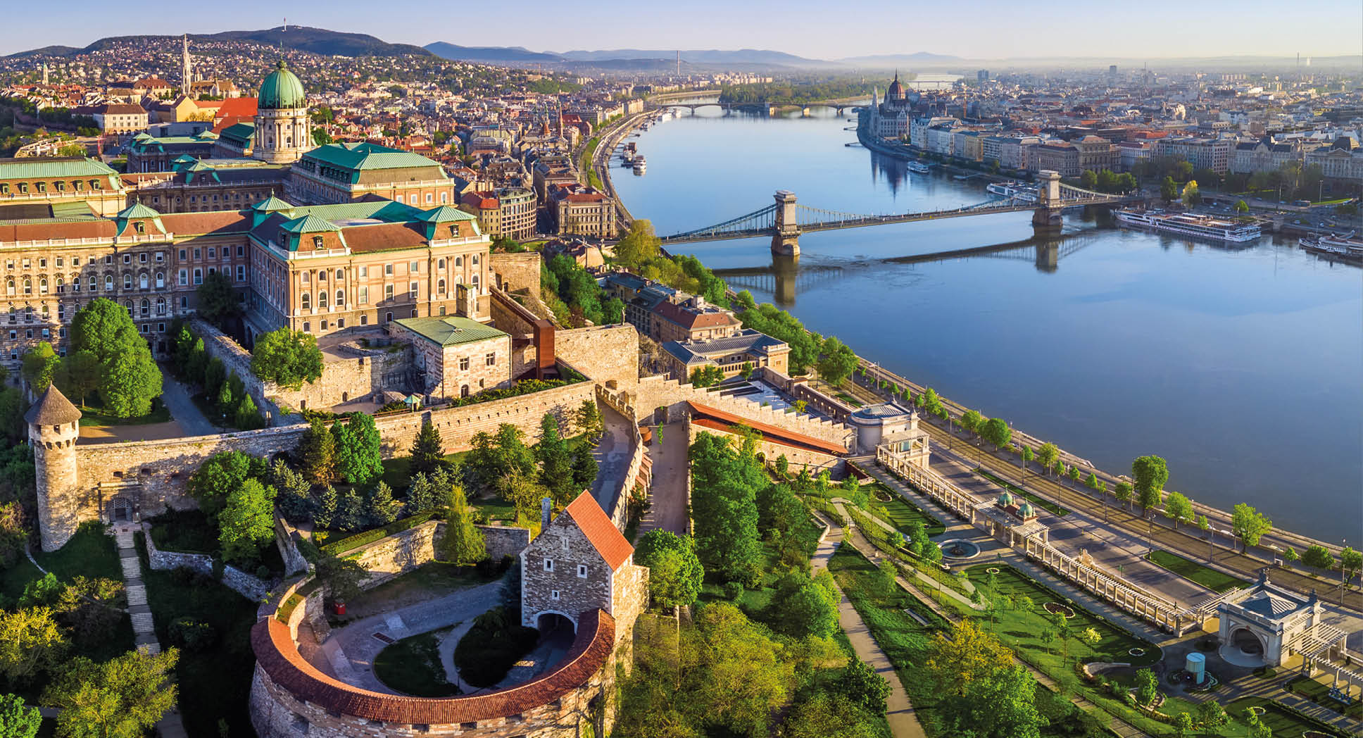 Budapest, Hungary - Aerial panoramic skyline view of Buda Castle Royal Palace with Szechenyi Chain Bridge, St.Stephen's Basilica, Hungarian Parliament and Matthias Church at sunrise with blue sky