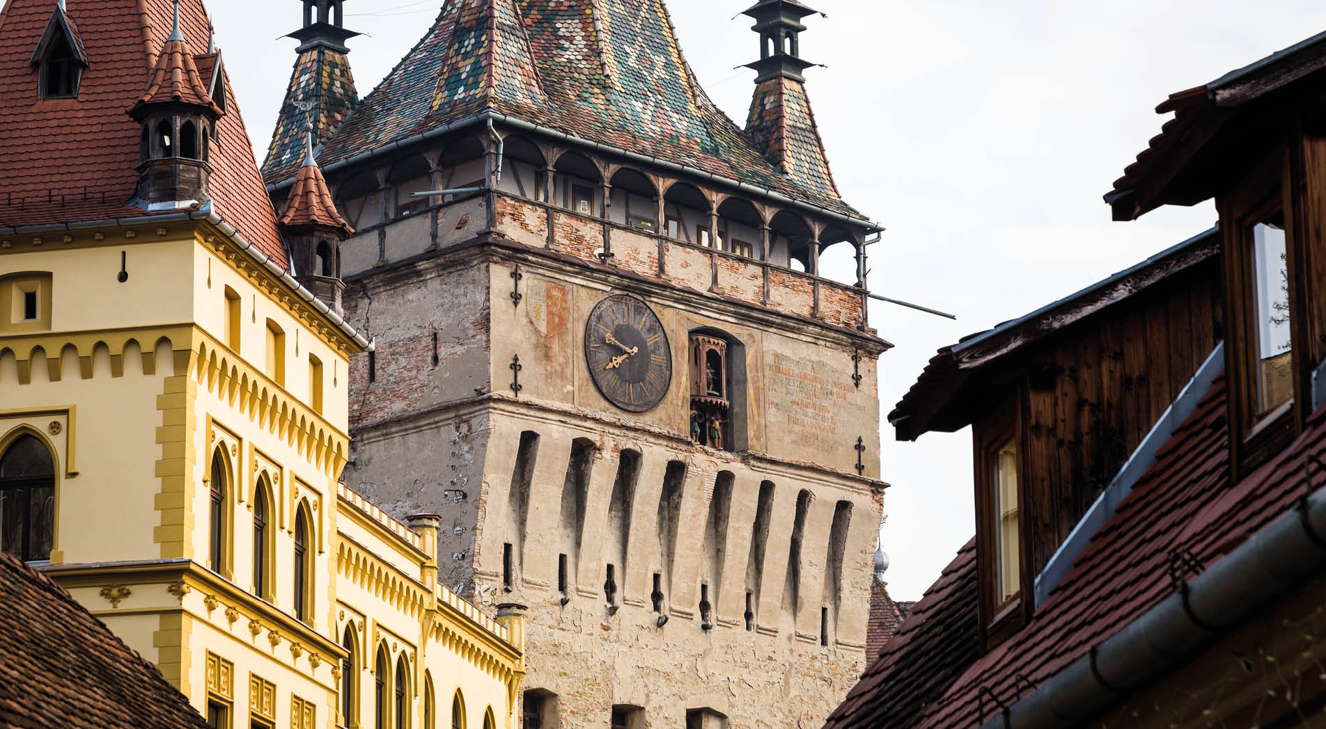 Old houses on a narrow street in the old town of Sighisoara, a small, historic town in the Transylvania region of Romania. Up ahead, at the end of the street, is an old church and clock tower in this truly ancient town that is the birthplace of Vlad Tepes, also known as Vlad the Impaler. Horizontal colour image with copy space.