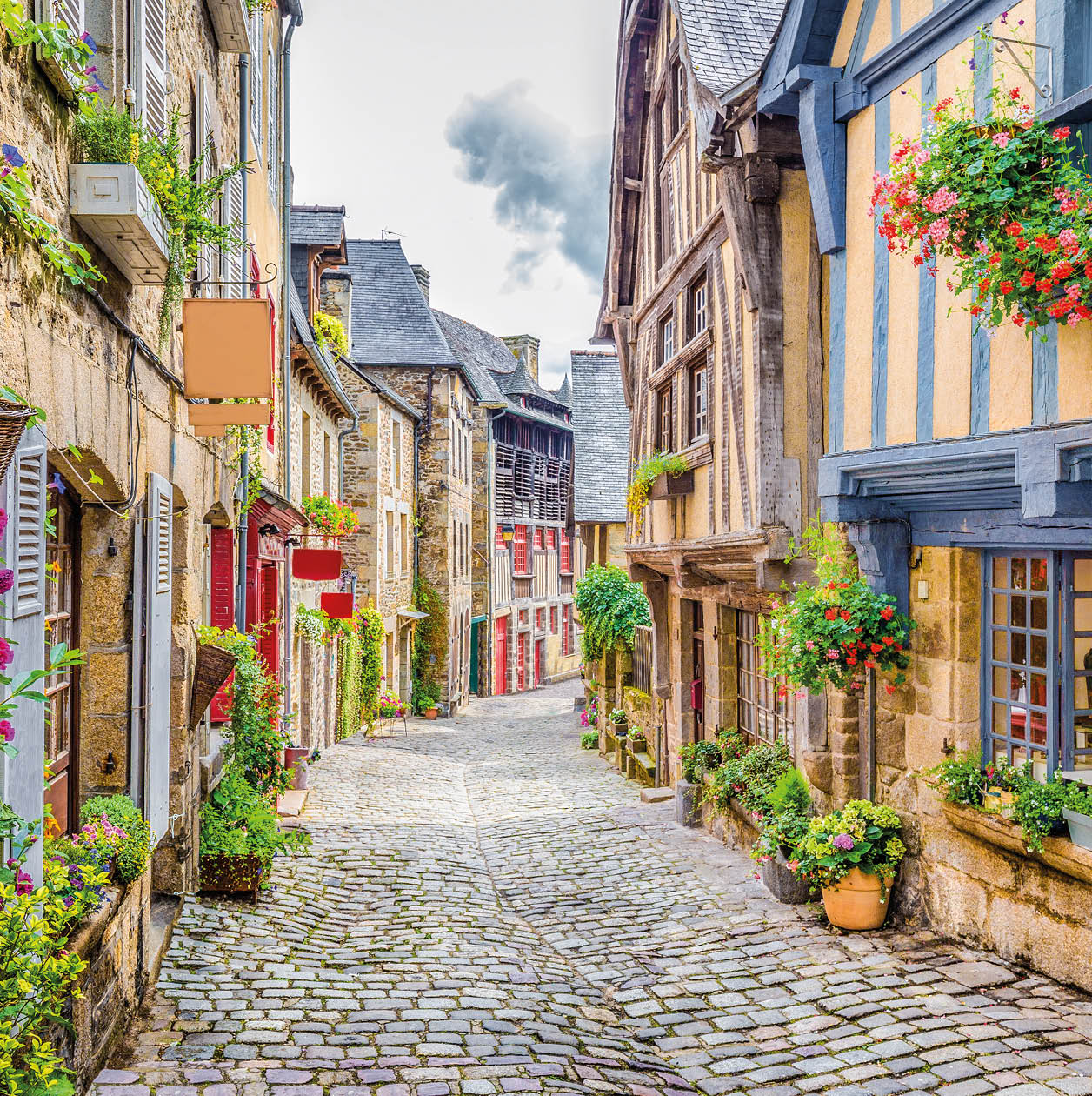 Beautiful view of scenic narrow alley with historic traditional houses and cobbled street in an old town in Europe with blue sky and clouds in summer with retro vintage Instagram grunge filter effect