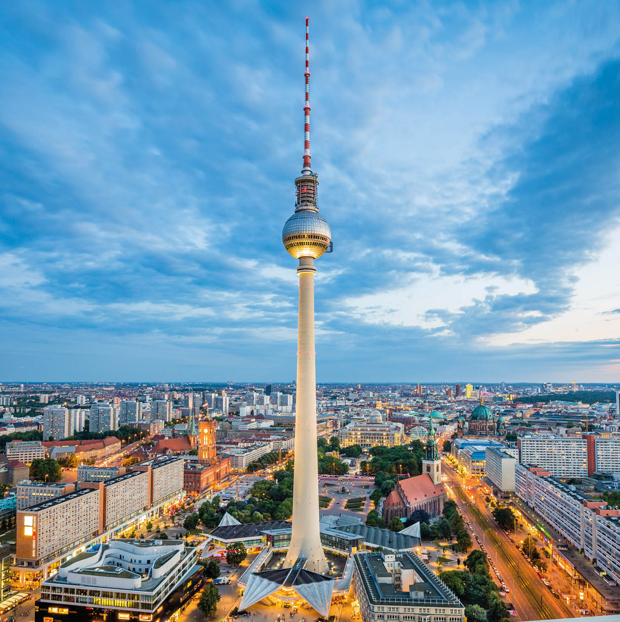 Aerial view of Berlin skyline with famous TV tower at Alexanderplatz and dramatic cloudscape in twilight during blue hour at dusk, Germany.