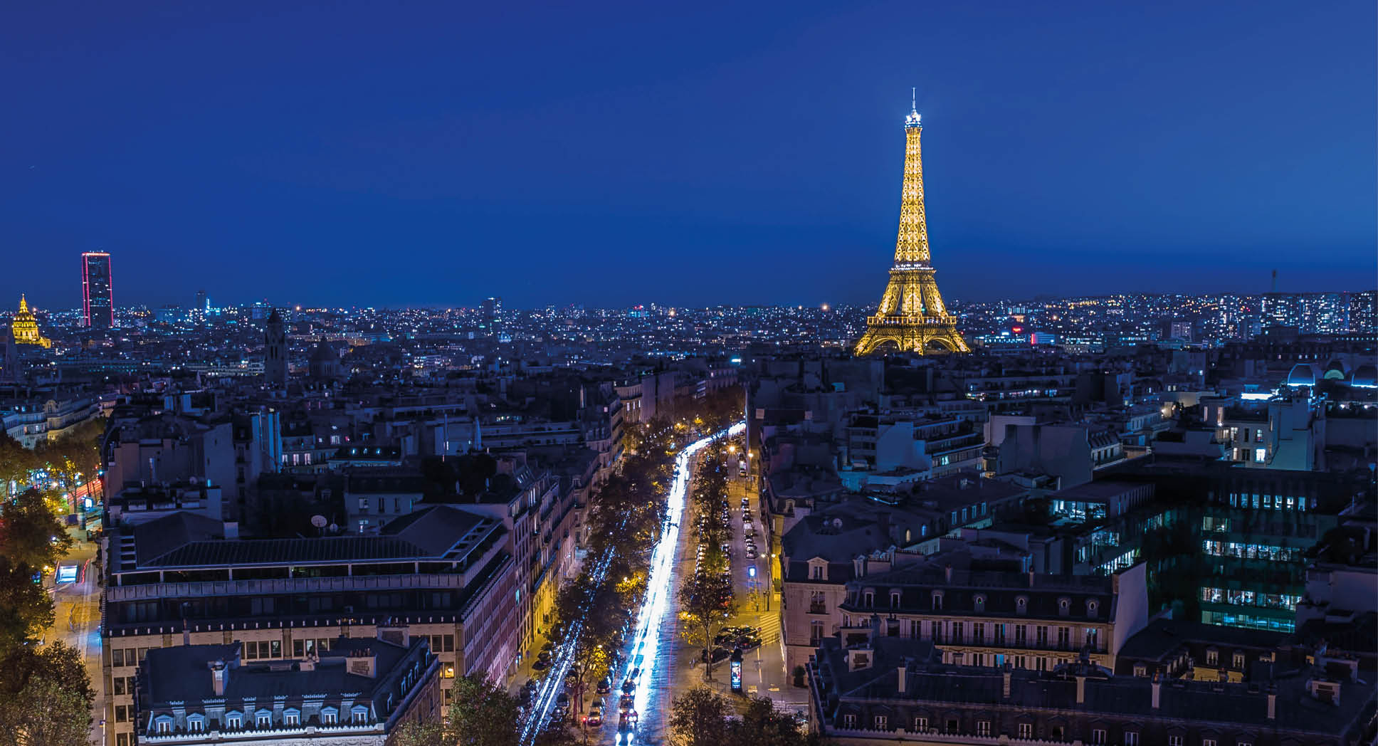 Illuminated Eiffel tower at night seen from the Arc de Triomphe in Paris