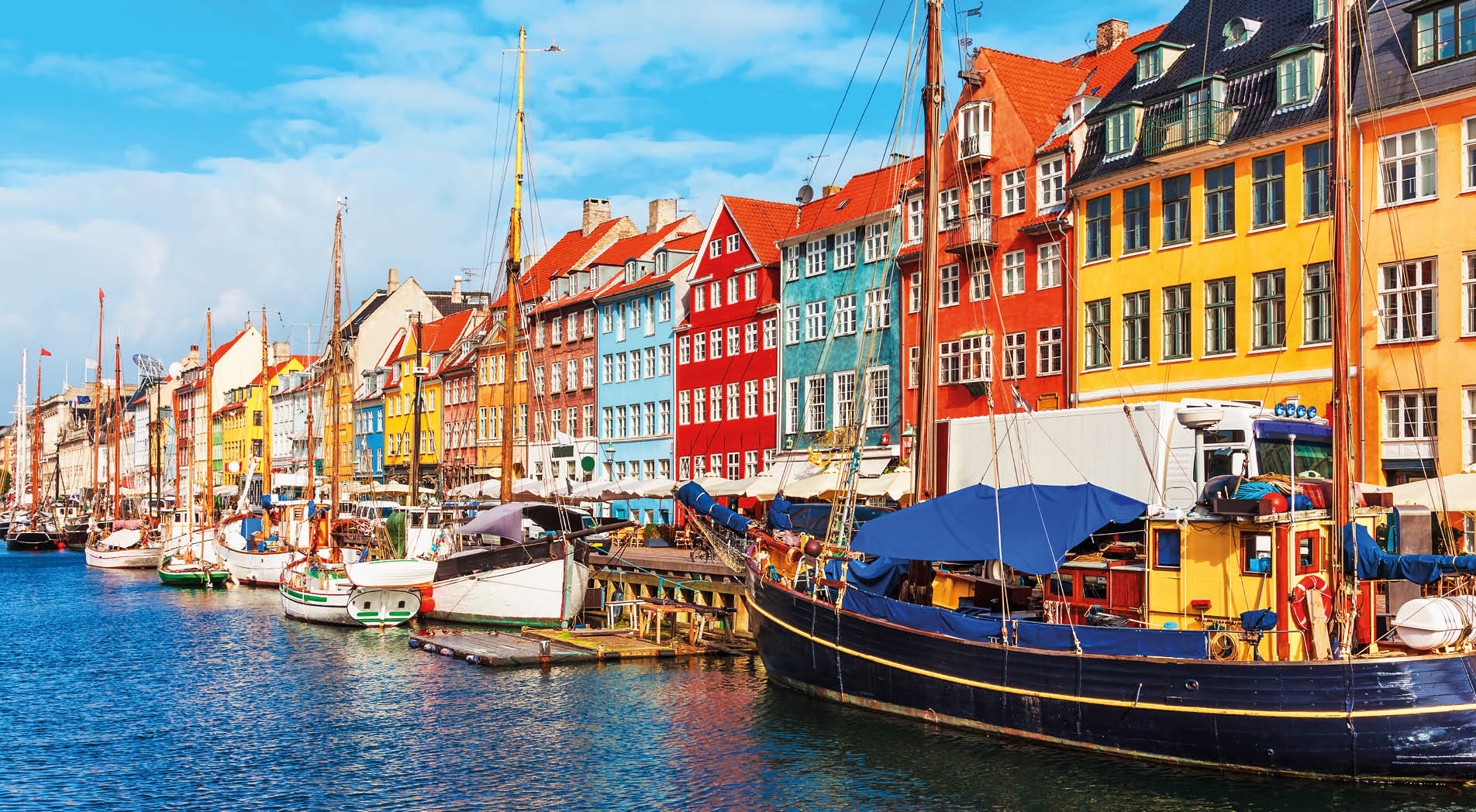 Scenic summer view of Nyhavn pier with color buildings, ships, yachts and other boats in the Old Town of Copenhagen, Denmark