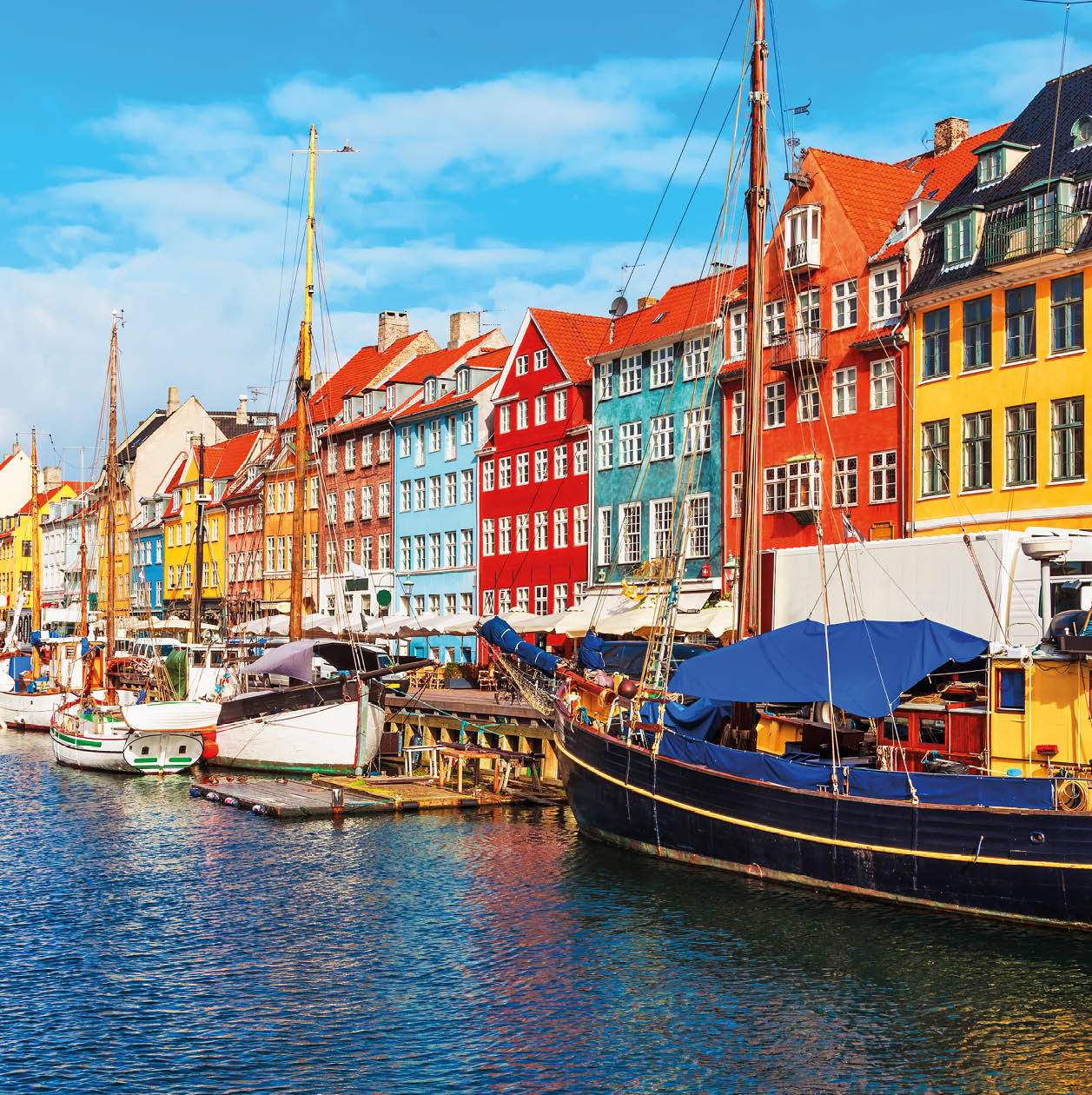 Scenic summer view of Nyhavn pier with color buildings, ships, yachts and other boats in the Old Town of Copenhagen, Denmark
