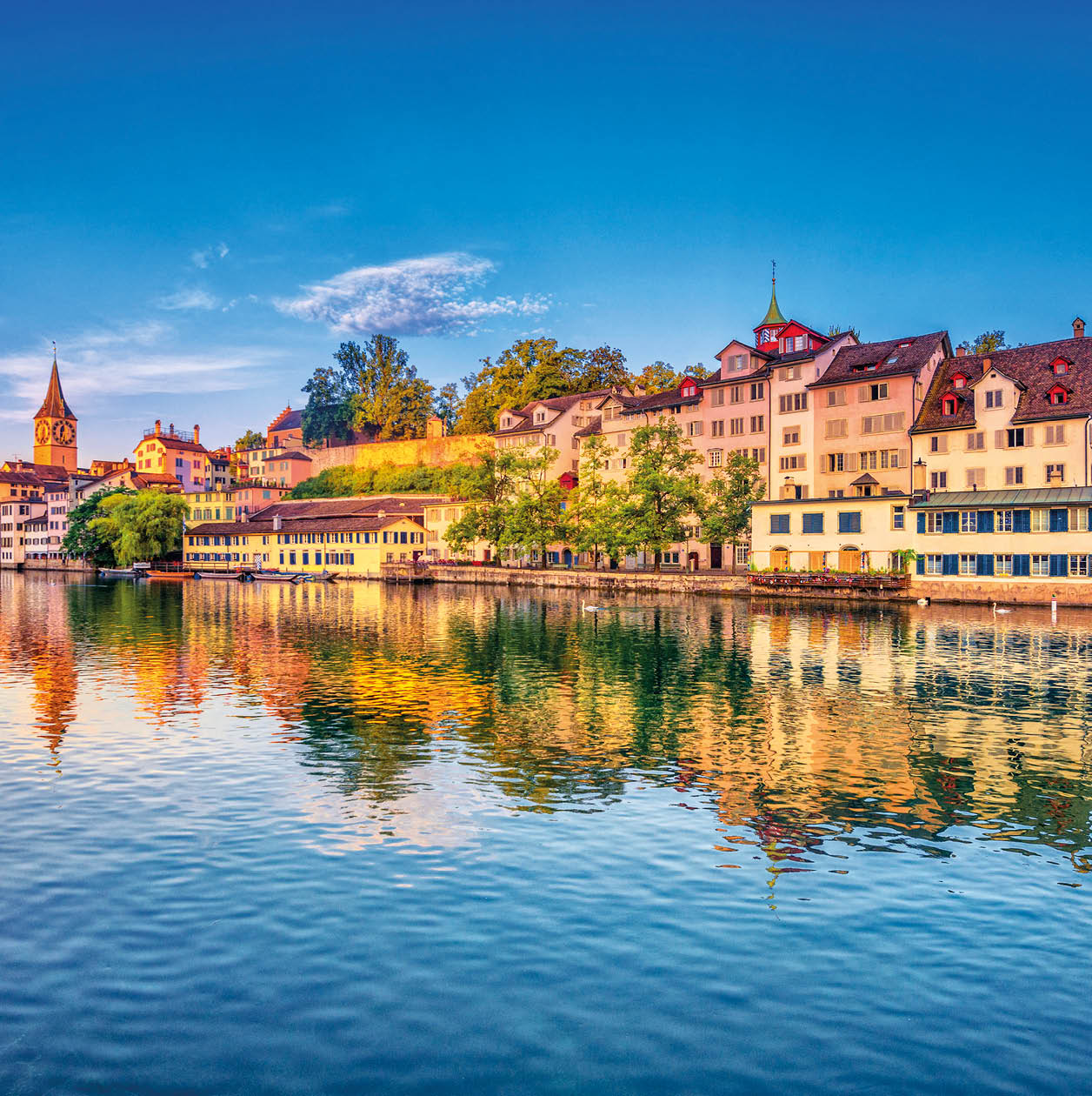 Sunrise in the historic downtown of Zurich at the Limmat River .