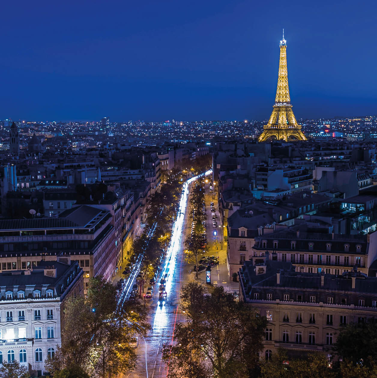 Illuminated Eiffel tower at night seen from the Arc de Triomphe in Paris