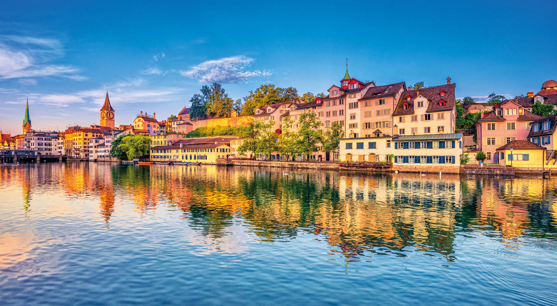 Sunrise in the historic downtown of Zurich at the Limmat River .