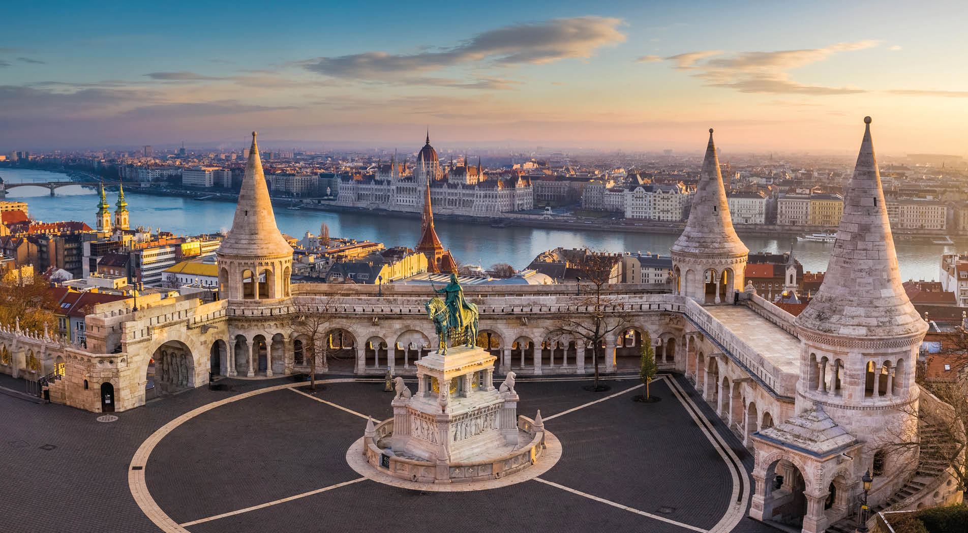 Budapest, Hungary - The famous Fisherman's Bastion at sunrise with statue of King Stephen I and Parliament of Hungary at background
