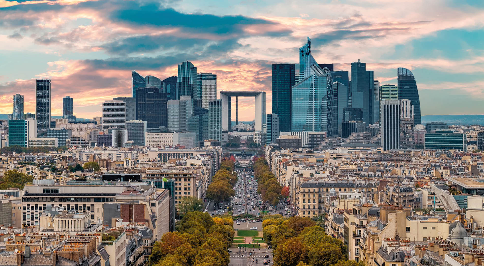 La Defense Financial District Paris France in autumn. Traffic on Champs-Elysees with orange and yellow trees aside. Modern vs. Old architecture