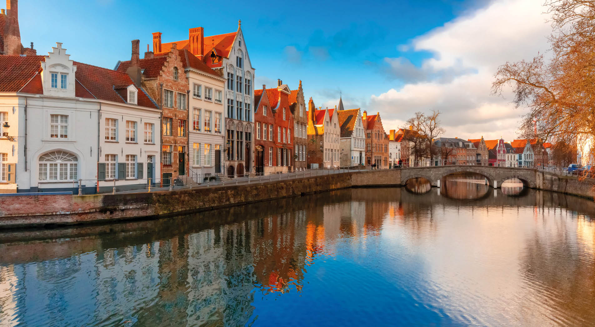 Scenic city view of Bruges canal Spiegelrei with beautiful medieval houses, their reflections and Bridge Carmersbrug, Belgium