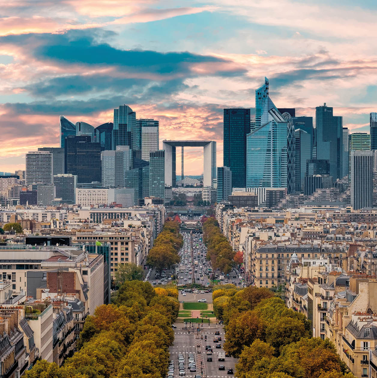 La Defense Financial District Paris France in autumn. Traffic on Champs-Elysees with orange and yellow trees aside. Modern vs. Old architecture