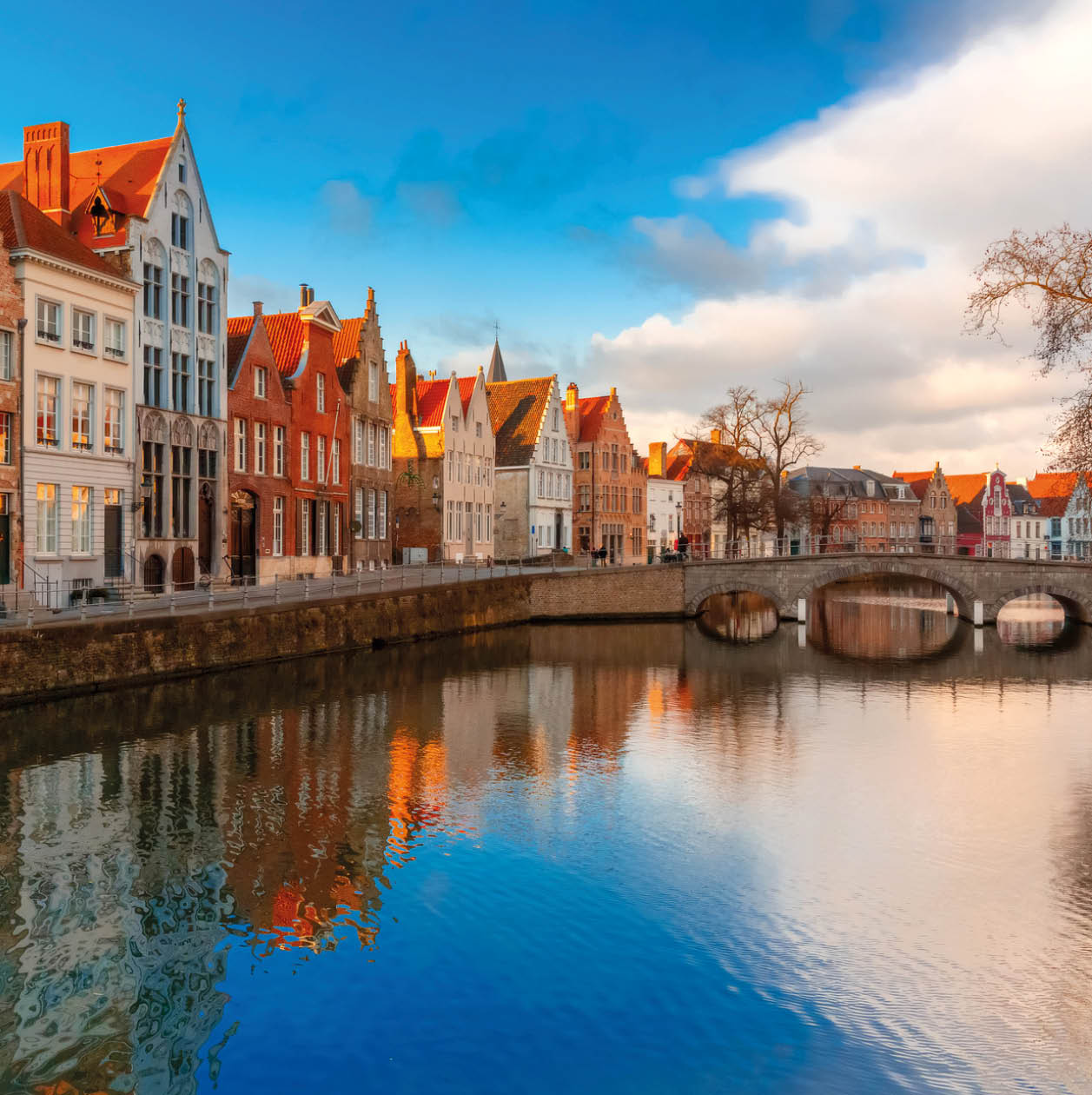 Scenic city view of Bruges canal Spiegelrei with beautiful medieval houses, their reflections and Bridge Carmersbrug, Belgium