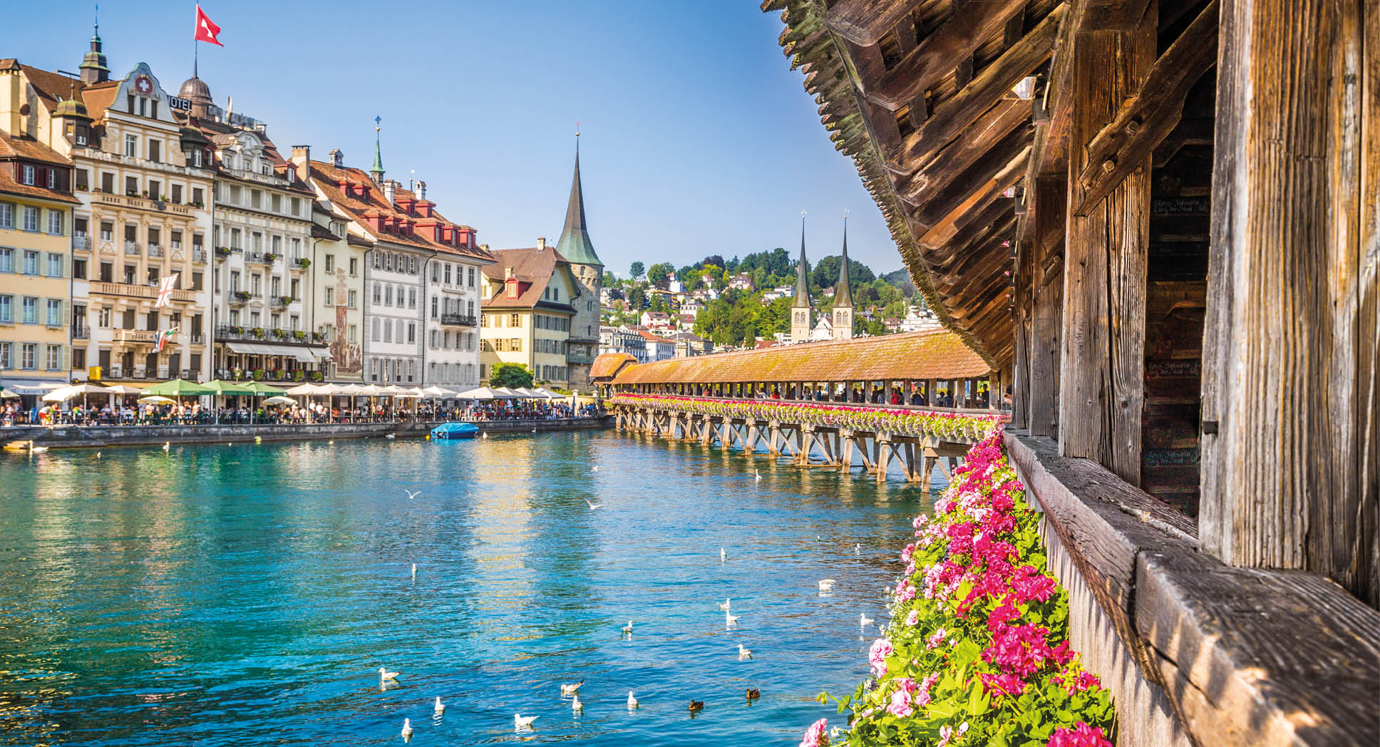 Famous Chapel Bridge in the historic city center of Lucerne, the city's symbol and one of Switzerland's main tourist attractions and views on a sunny day in summer, Canton of Lucerne, Switzerland.