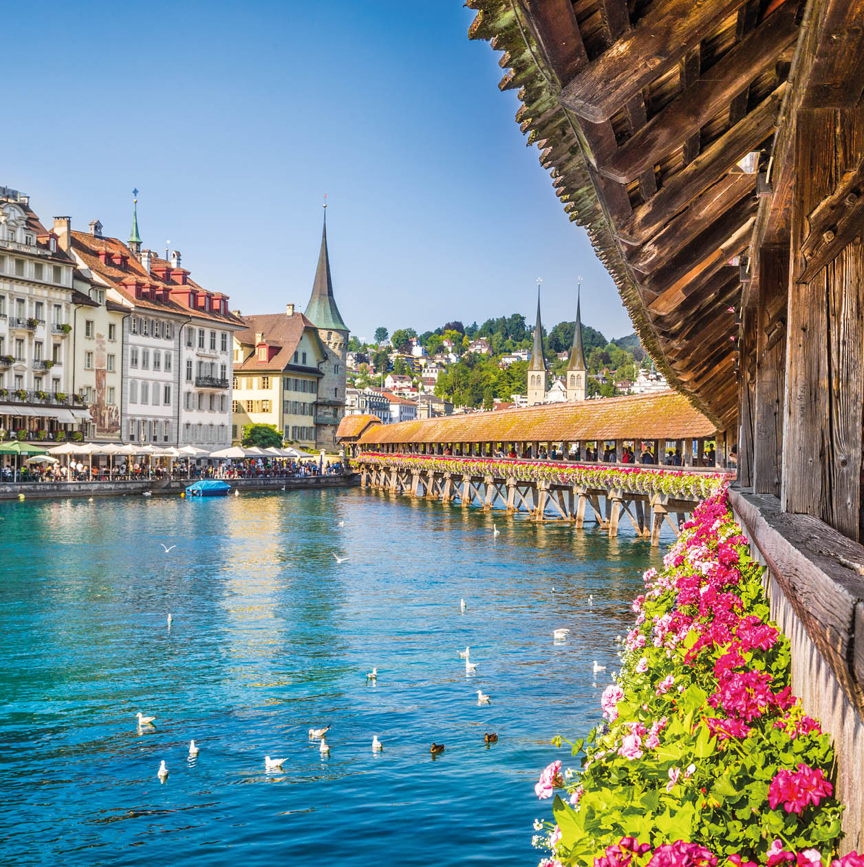 Famous Chapel Bridge in the historic city center of Lucerne, the city's symbol and one of Switzerland's main tourist attractions and views on a sunny day in summer, Canton of Lucerne, Switzerland.