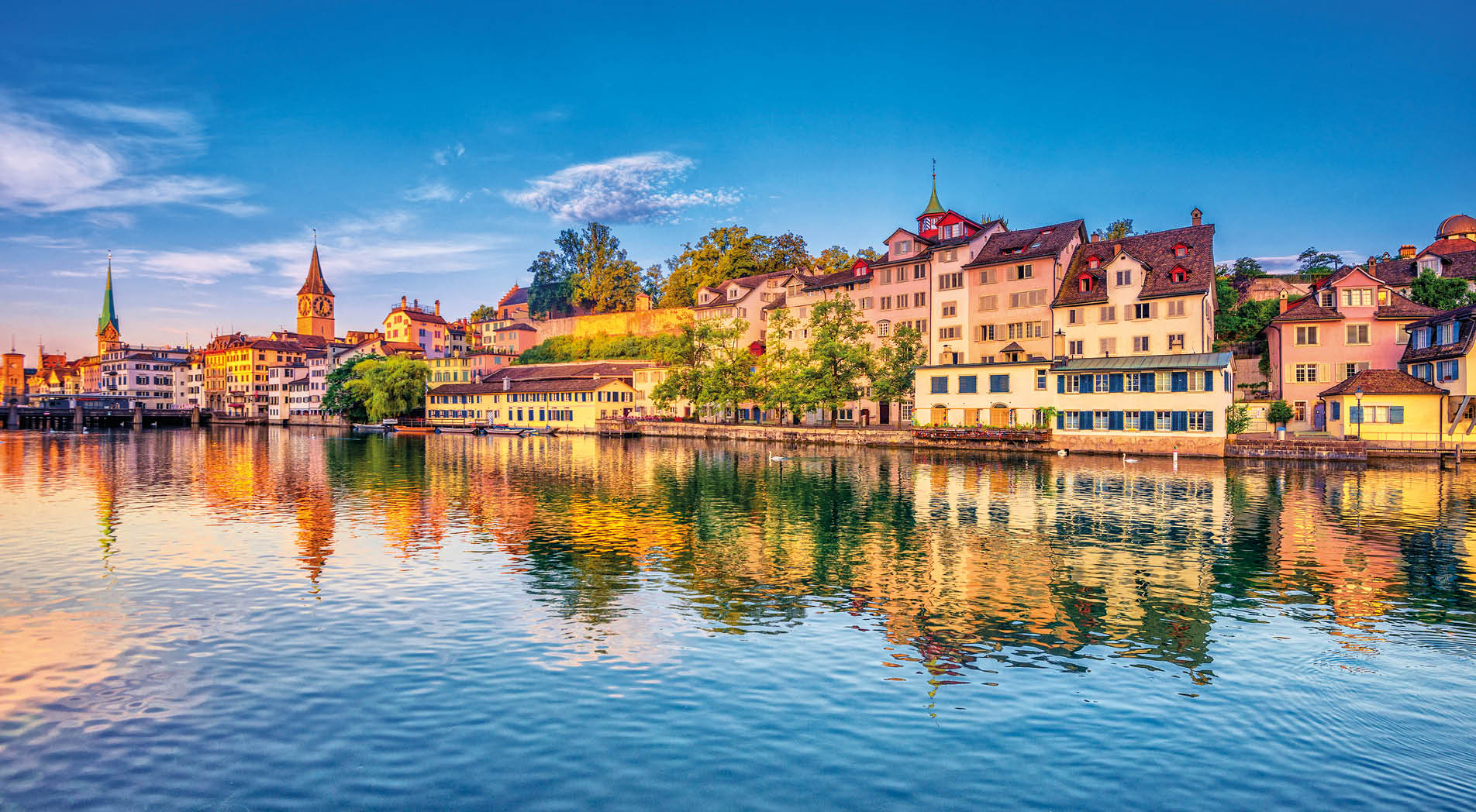 Sunrise in the historic downtown of Zurich at the Limmat River .