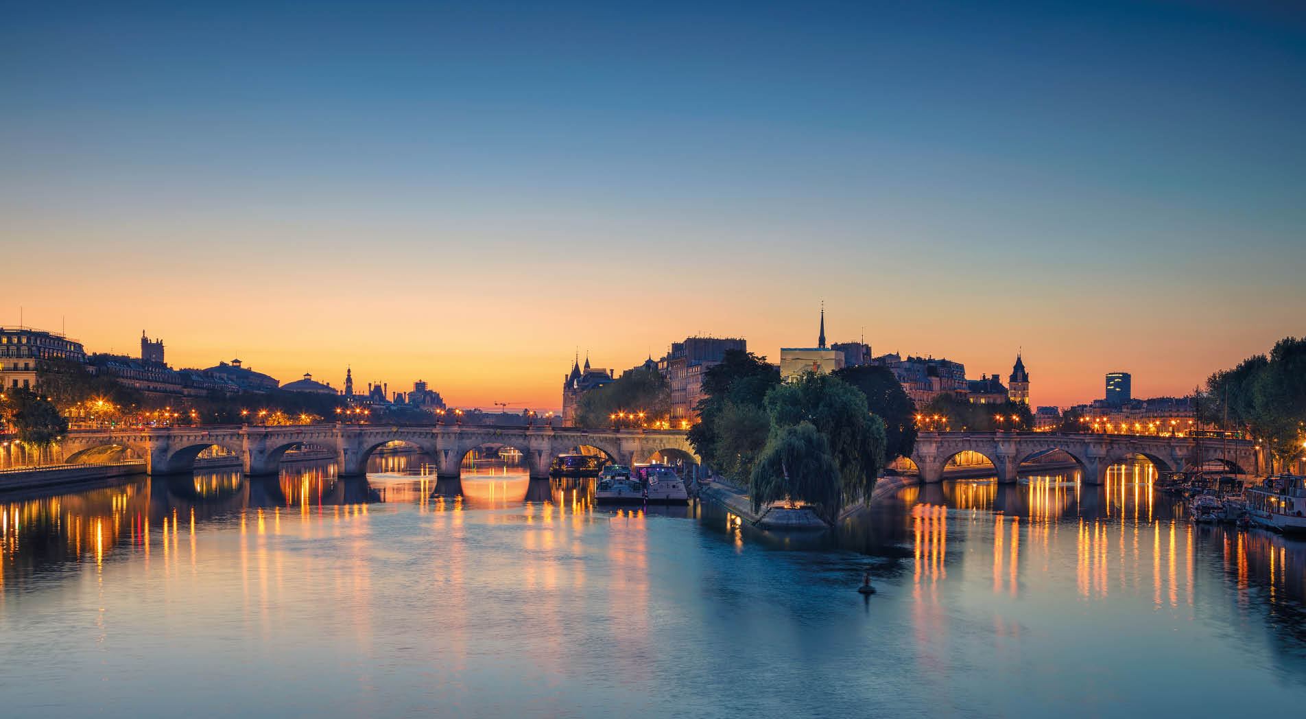 Panoramic image of Paris riverside during sunrise.
