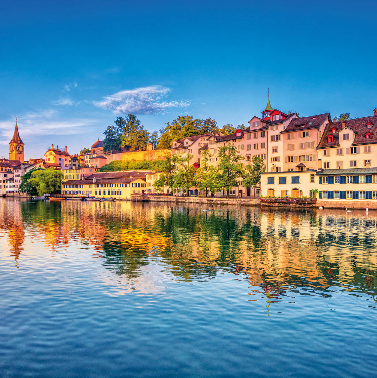 Sunrise in the historic downtown of Zurich at the Limmat River .