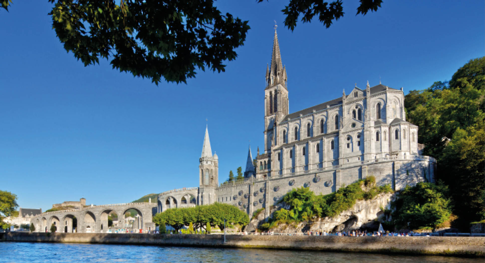 “Cathedral of Lourdes, FranceBelow the Basilique behind the trees the Grotte de MassabilleLourdes is a small market town lying in the foothills of the Pyrenees, famous for the Marian apparitions of Our Lady of Lourdes that are reported to have occurred in 1858 to Bernadette Soubirous."