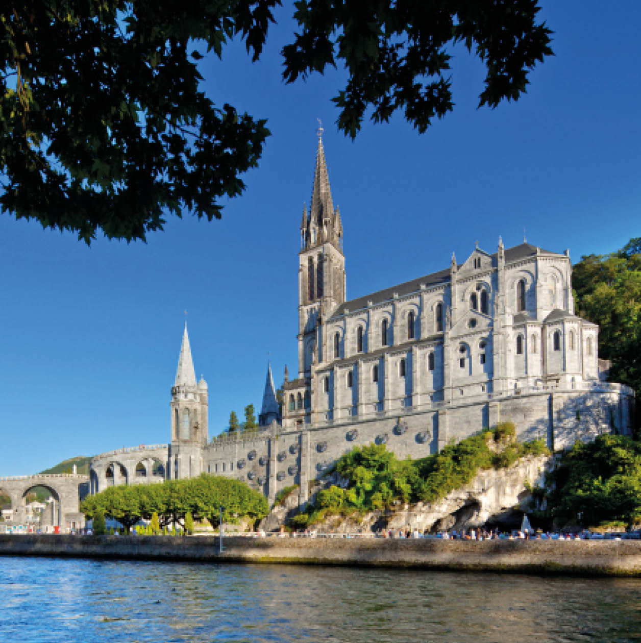“Cathedral of Lourdes, FranceBelow the Basilique behind the trees the Grotte de MassabilleLourdes is a small market town lying in the foothills of the Pyrenees, famous for the Marian apparitions of Our Lady of Lourdes that are reported to have occurred in 1858 to Bernadette Soubirous."