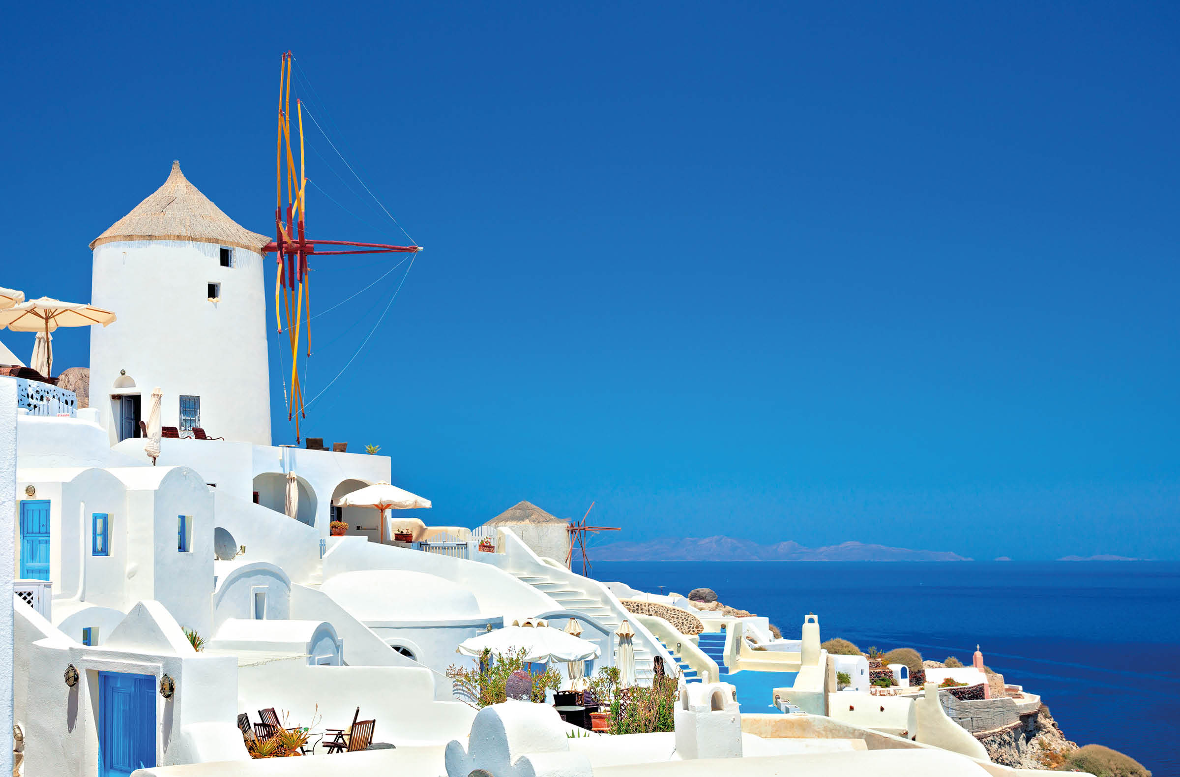 View of carved out of the cliffs houses of Oia, Santorini island, Greece.